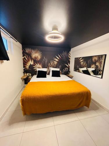 a bedroom with a large bed with a yellow blanket at GÎTE Au 21 Loveroom in Beaumont-la-Ronce