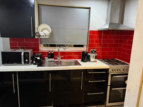 ブラッドフォードにあるCosy Stay Near Arena & Leeds Bradford Airport two bedroom Houseのシンクと電子レンジ付きのキッチン