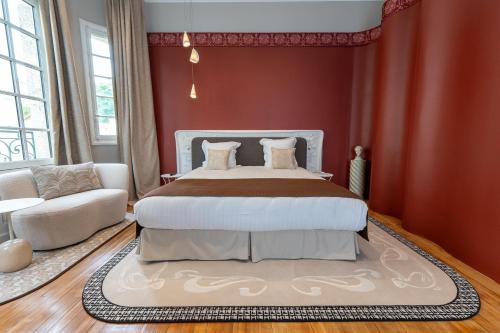a bedroom with a large bed with red walls at Hôtel des Arts in Angoulême