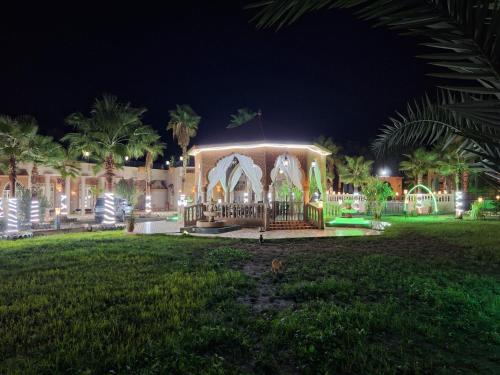 a building with lights in a park at night at Eden Suites 
