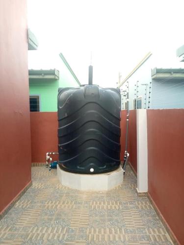 a large black object is sitting in a room at FranGee gold house with cool breeze & solar backup in Kpomkpo