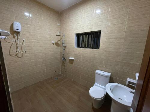 a bathroom with a toilet and a sink at Comfort Stay Apartments Cadjehoun in Cotonou