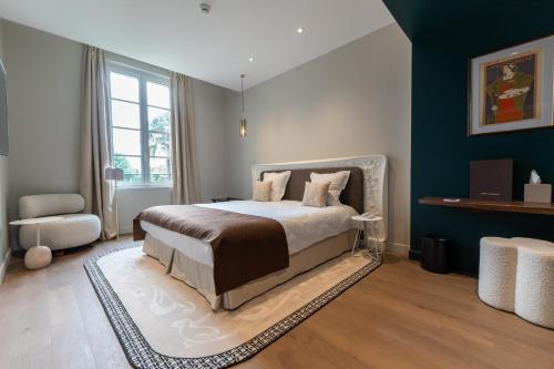 a bedroom with a bed and a large window at Hôtel des Arts in Angoulême