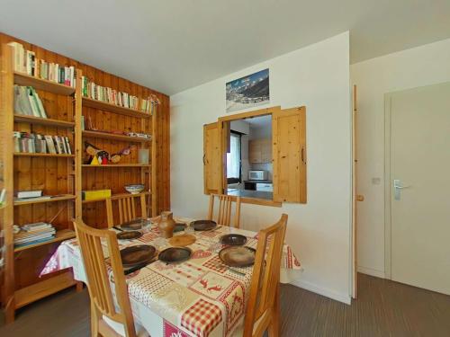 une salle à manger avec une table, des chaises et des étagères dans l'établissement Appartement au centre - 3 pièces, 6 personnes, ascenseur - FR-1-241-222, au Grand-Bornand