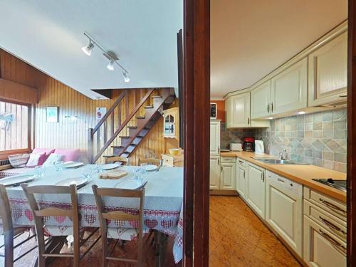 une cuisine avec une table et des chaises ainsi qu'un escalier dans l'établissement Appartement spacieux 8 pers avec cheminée, parking et vue montagne - FR-1-241-250, au Grand-Bornand