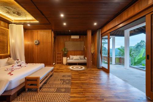 a bedroom with a bed and a living room at The Lumbung Jaya Resort in Tegalalang
