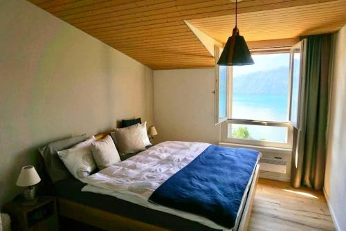 a bedroom with a bed with a large window at Ruhe-Oase mit traumhafter Sicht auf den Vierwaldstättersee in Weggis