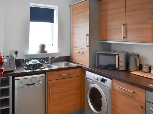 a kitchen with a sink and a washing machine at The Bandstand Sea View in Blythe