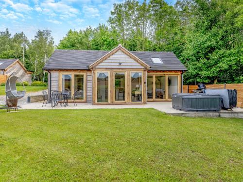 a house with a large backyard with a barbecue at Loxford Lodge - Uk47304 in Uttoxeter