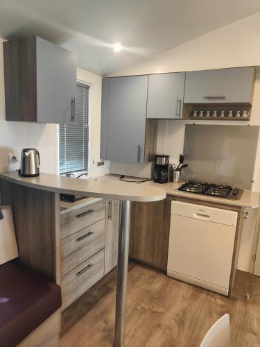 une cuisine avec des armoires blanches et un comptoir dans l'établissement Cottage au camping Le Ried - Proche Europa Park, à Boofzheim