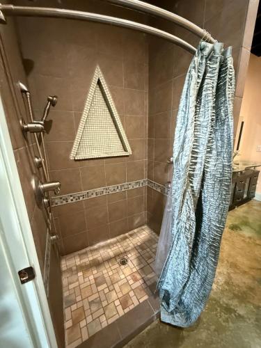 a shower with a blue shower curtain in a bathroom at Down on the BAY in Coden