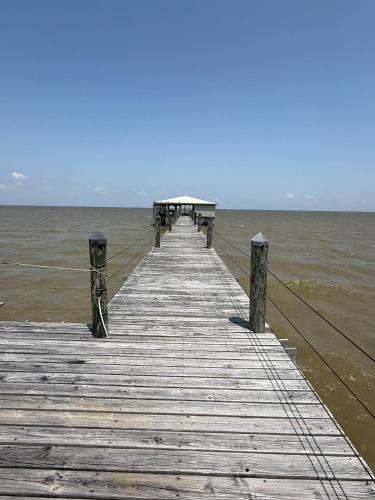 a wooden pier in the middle of the ocean at Down on the BAY in Coden