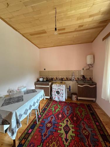 a living room with a table and a rug at Quba Dağ Mənzərəli Bağ Evi Quba Mountain View Garden House in Küsnǝt