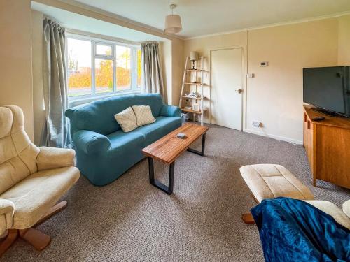 a living room with a blue couch and a coffee table at Lowal House - Uk46054 in Saffron Walden
