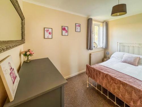 a bedroom with a bed and a table with flowers on it at Lowal House - Uk46054 in Saffron Walden