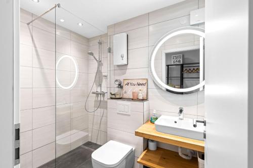 a bathroom with a sink toilet and a mirror at Ferienwohnung Harmonie mit Pool und Fitness in Sankt Englmar