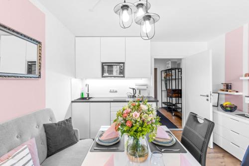 a kitchen and dining room with a table with a vase of flowers at Ferienwohnung Harmonie mit Pool in Sankt Englmar