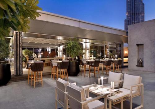 a patio with tables and chairs and a restaurant at Fashion Avenue Dubai Mall in Dubai