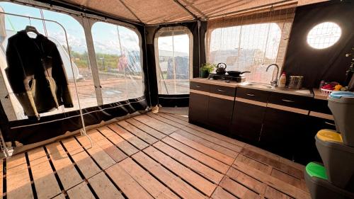 a room with a kitchen with windows and a sink at COOL PEOPLE LIVE HERE! Przyczepa w Jastarni in Jastarnia