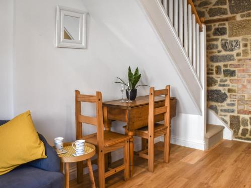 Cette chambre comprend une table, une chaise et un canapé. dans l'établissement Dalton Cottage, à Penzance