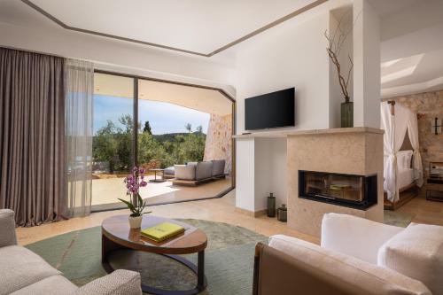 a living room with a fireplace and a tv at Villa Nai 3.3 in Žman