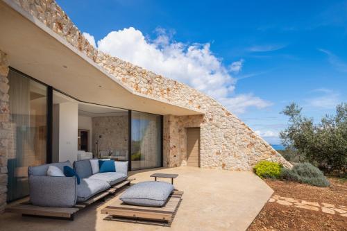 a patio of a house with two couches and a table at Villa Nai 3.3 in Žman
