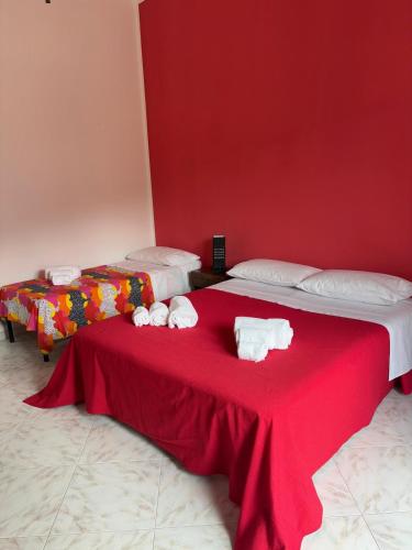 two beds in a room with red walls at Casa Vacanze Lenza in Brattirò