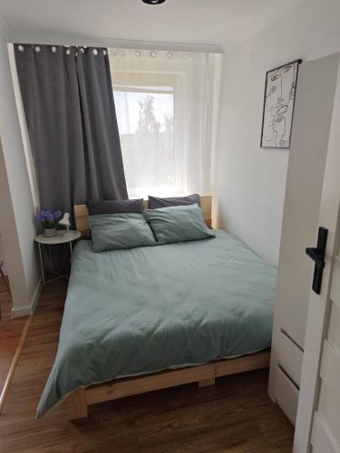 a bedroom with a large bed with a window at Apartament na Krakowskiej w Dębicy in Dębica