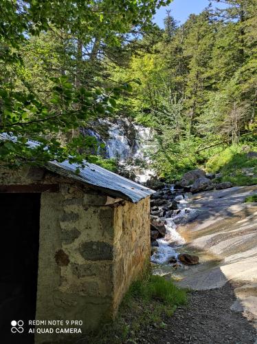 a stone building next to a river with trees at Capstay Lourdes - Residence Serenity in Lourdes