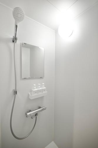 a shower with a shower head in a bathroom at Hotel KOTO in Sapporo