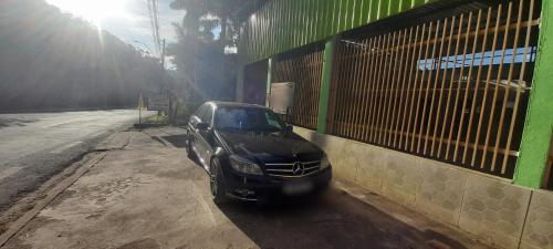 a black car parked next to a building at Dormitório portal in Domingos Martins