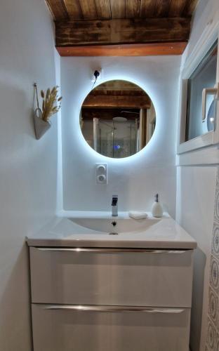 une salle de bain avec un lavabo et un miroir dans l'établissement Maison au calme avec vue sur montagne, à Ornolac-Ussat-les-Bains
