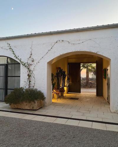 a white building with an open doorway with a patio at Galeta Masseria in Nardò
