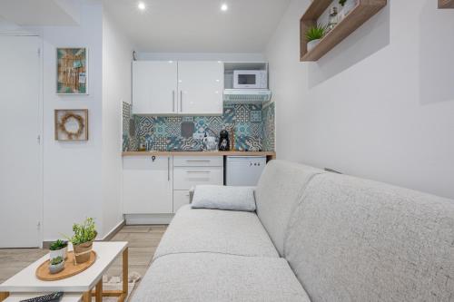 un salon avec un canapé et une cuisine dans l'établissement Nid cosy à 5min de la mer avec climatisation, à Nice