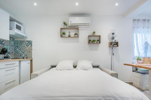 une chambre avec un grand lit blanc dans une pièce dans l'établissement Nid cosy à 5min de la mer avec climatisation, à Nice
