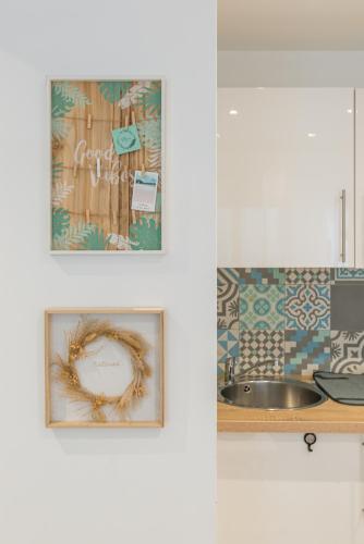 une cuisine avec 2 photos sur le mur et un évier dans l'établissement Nid cosy à 5min de la mer avec climatisation, à Nice