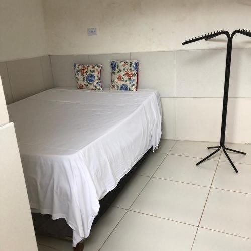 a bedroom with a bed with a white sheets and pillows at Especial Beira Mar in Maragogi