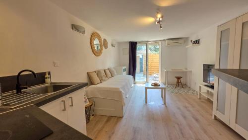 une cuisine et un salon avec un canapé dans l'établissement Studio avec terrasse et vrai lit 160x200cm, indépendant calme absolu dans maison de famille, à La Valette-du-Var