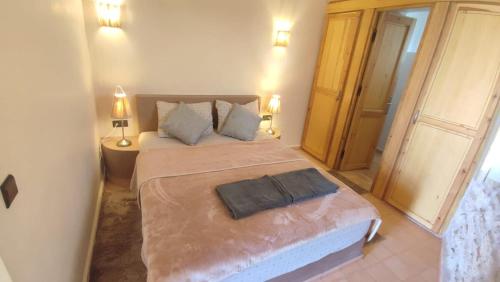a bedroom with a large bed with two lamps at The Little Beach Cottage in Sidi Kaouki