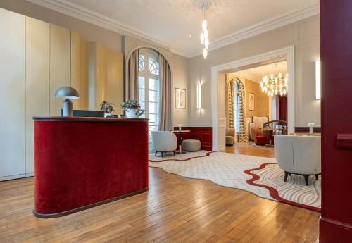 a living room with a red counter in the middle at Hôtel des Arts in Angoulême