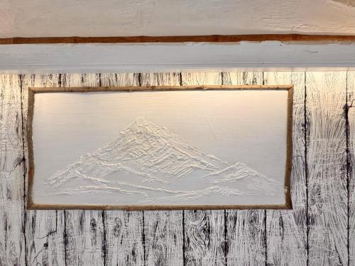 a picture of a mountain in a wooden frame at Aikkya Farms in Mukteswar