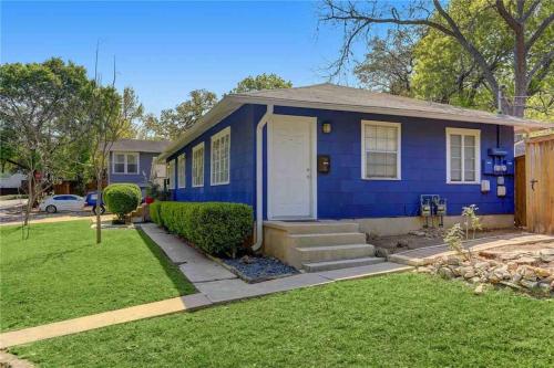 una casa azul con una puerta blanca en un patio en Downtown ATX! Deep Eddy Bungalow #B, en Austin