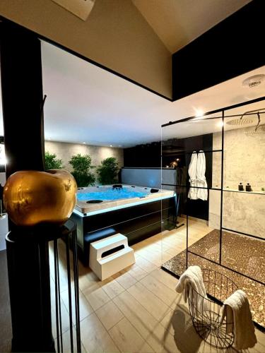 La salle de bains est pourvue d'une piscine et d'une baignoire. dans l'établissement La Charmeuse, suite luxueuse romantique & spa, à Belin-Beliet
