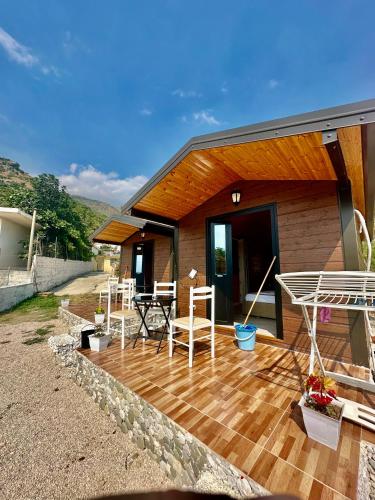 ein Haus mit einer Holzterrasse mit einem Tisch und Stühlen in der Unterkunft Tony Home in Borsh