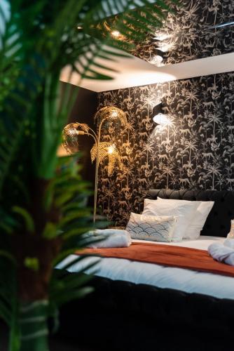 - une chambre dotée d'un lit avec un mur à motifs dans l'établissement La Charmeuse, suite luxueuse romantique & spa, à Belin-Beliet