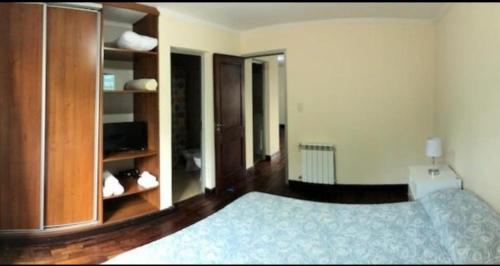 a bedroom with a bed with a blue bedspread at Departamento Caseros in Salta