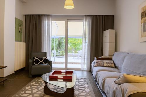 a living room with a couch and a table at Verdant Escape Corfu in Corfu