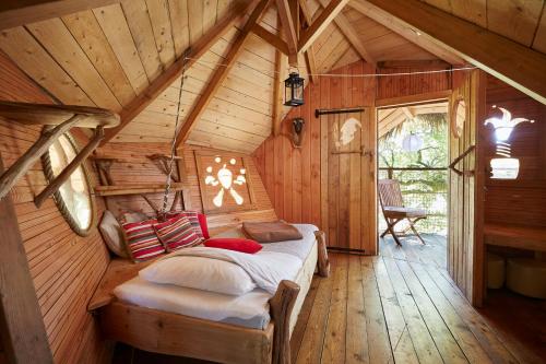 a bed in a room in a wooden cabin at Cabanes de la Grande Noe in Les Épasses