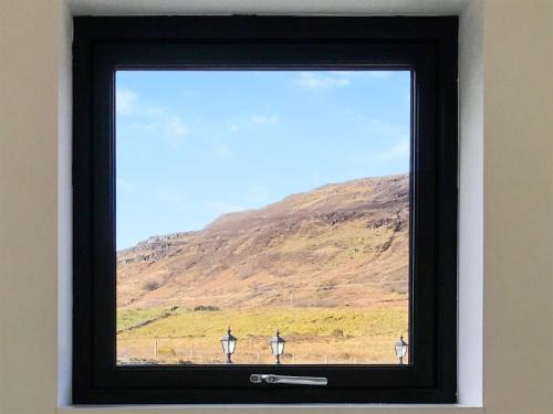 a window with a view of a hill at Faodail in Portree