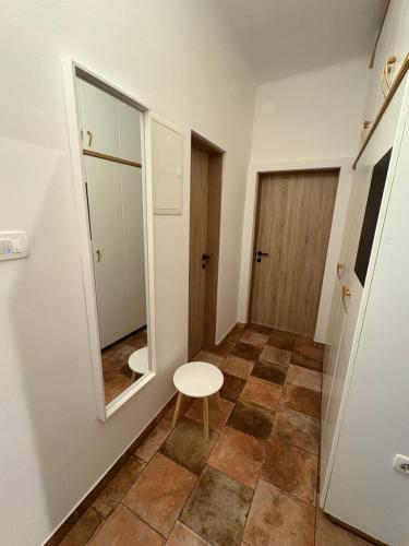 a small bathroom with a mirror and a stool at Apartma Arja in Spodnje Gorje